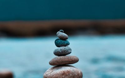 Smooth stones stacked in a balanced pile on a neutral background.